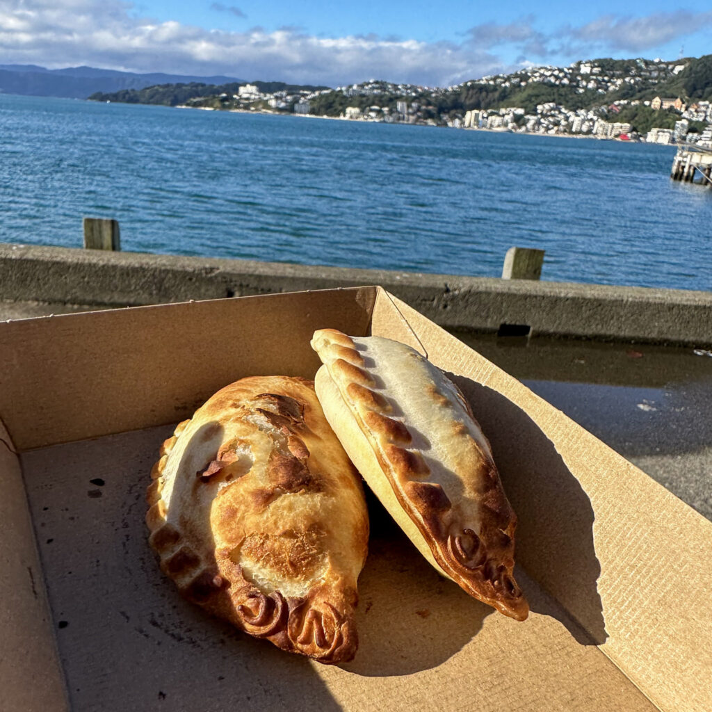 Two empanads with the wellington harbour in the background