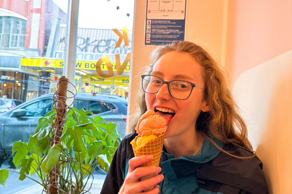 Ashley eating a vegan mango ice cream in a cone from duck island