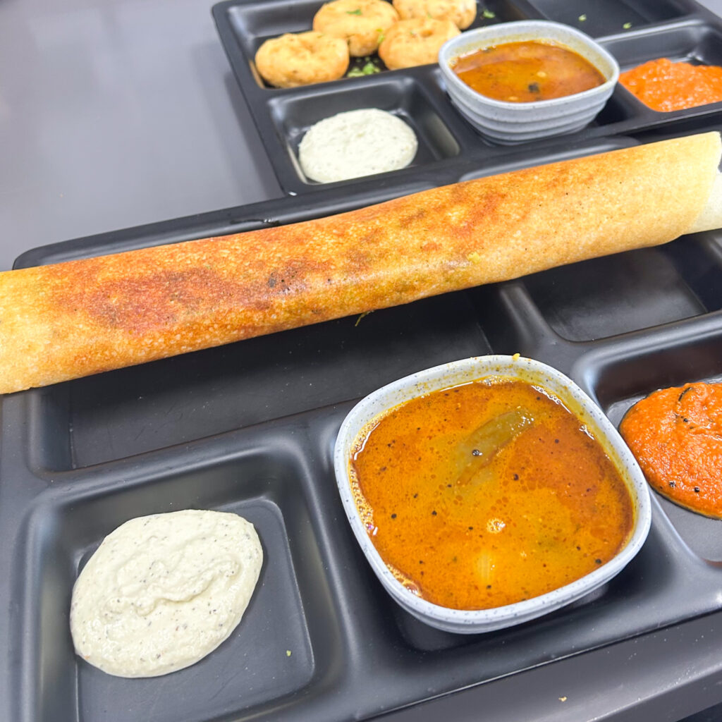 Vegan dosa with three curries in a tray